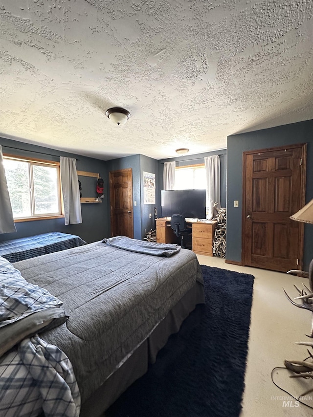 carpeted bedroom with multiple windows and a textured ceiling