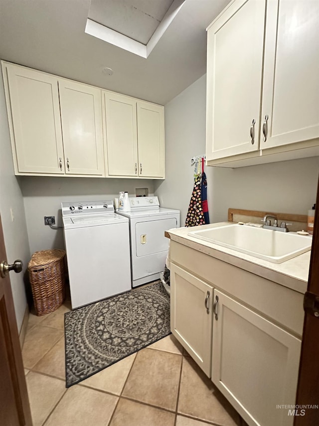 clothes washing area with a sink, cabinet space, separate washer and dryer, and light tile patterned flooring