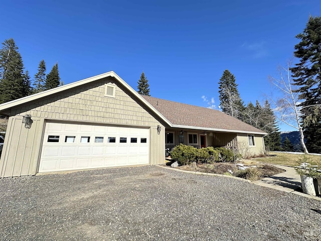 single story home featuring a garage, driveway, and a shingled roof