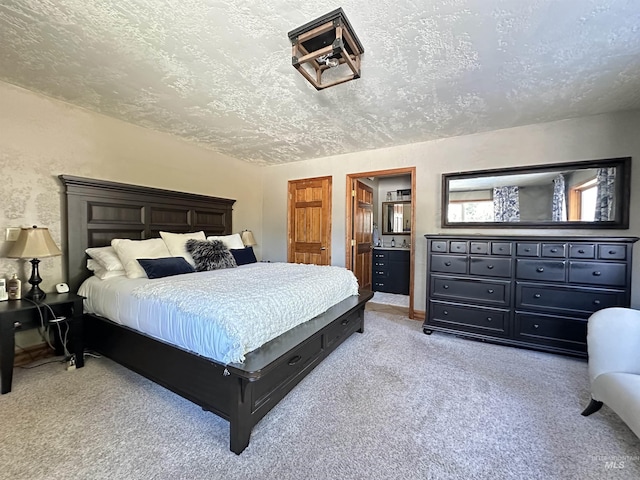 bedroom with connected bathroom, a textured ceiling, baseboards, and carpet floors