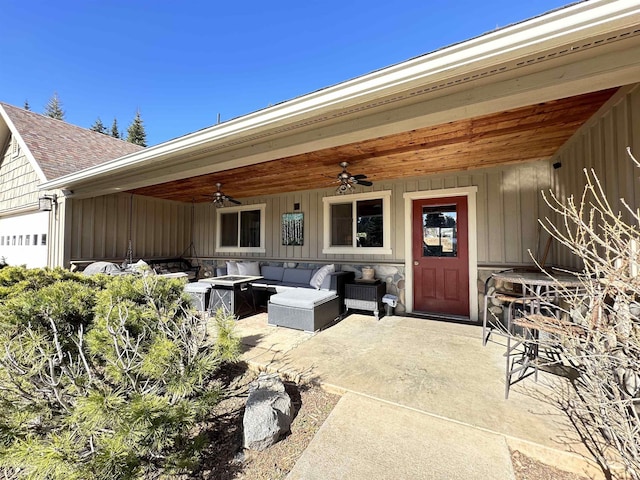 doorway to property featuring board and batten siding, a shingled roof, a patio, outdoor lounge area, and a ceiling fan