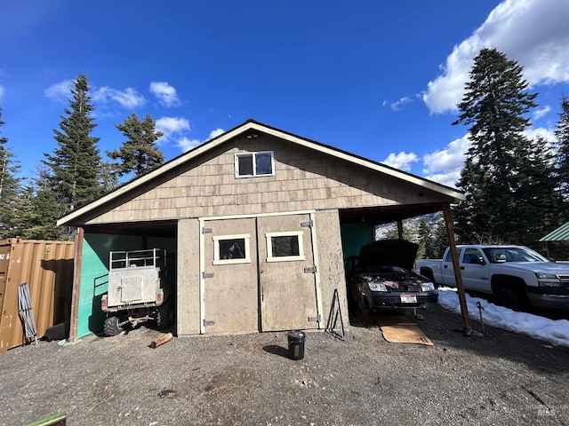 view of outdoor structure with a carport and fence