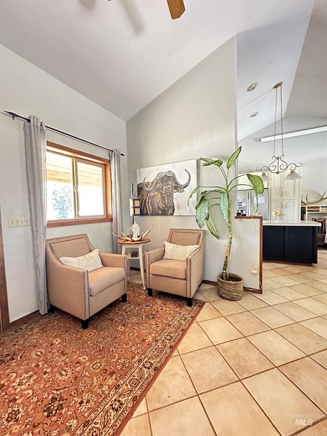 living area with light tile patterned floors, a ceiling fan, and vaulted ceiling