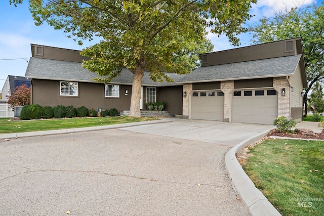 view of front facade featuring brick siding, roof with shingles, driveway, and an attached garage