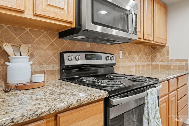 kitchen with backsplash, stainless steel appliances, light stone countertops, and light brown cabinets