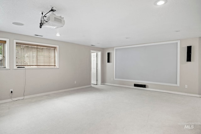 carpeted home theater room featuring a textured ceiling