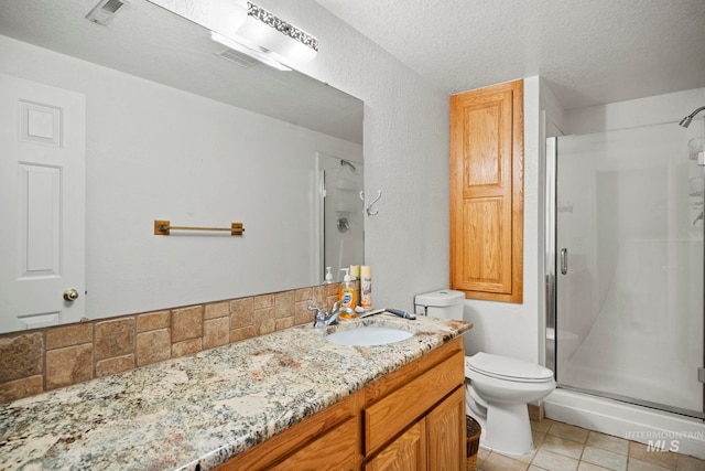 bathroom featuring tile patterned floors, toilet, vanity, a textured ceiling, and walk in shower