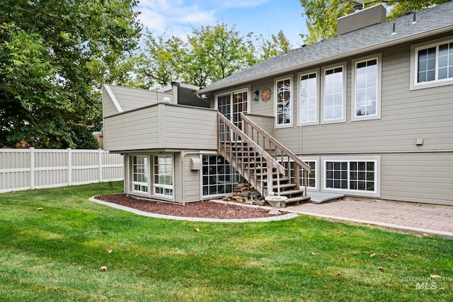 back of property featuring a patio, a yard, and a sunroom