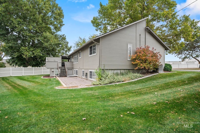 back of property featuring a lawn, stairway, and fence