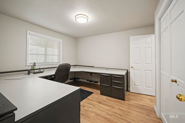 office area with a textured ceiling and light wood finished floors