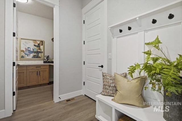 mudroom with visible vents, baseboards, and wood finished floors