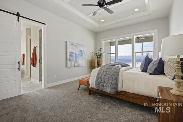 bedroom featuring crown molding, connected bathroom, a barn door, a raised ceiling, and baseboards