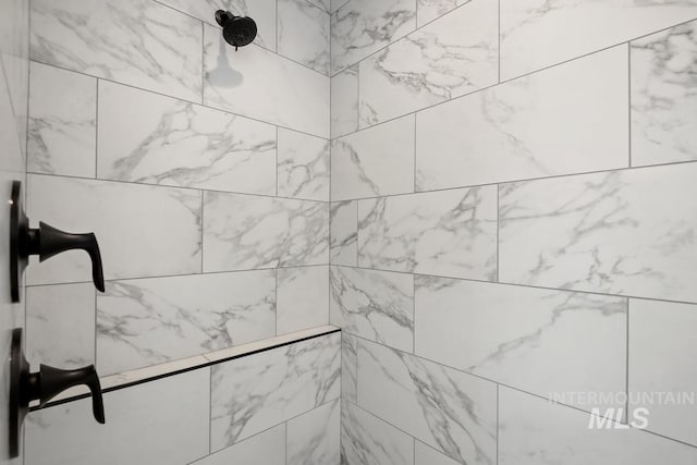 interior details with a tile shower