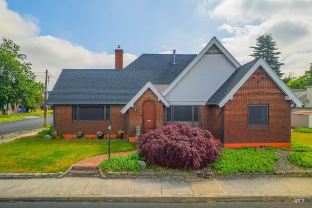 103 Prospect Ave, Lewiston, ID 83501 - english style home featuring brick siding, board and batten siding, a chimney, a front lawn, and a shingled roof