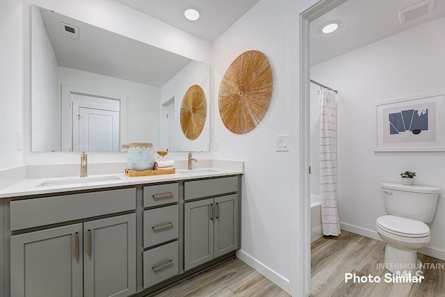 full bathroom featuring vanity, hardwood / wood-style flooring, toilet, and shower / bath combo