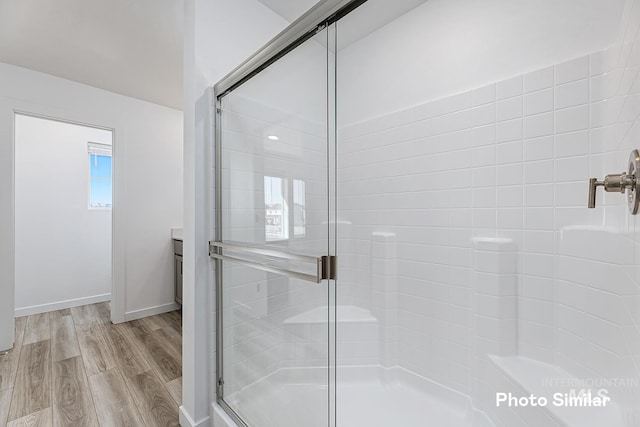 bathroom featuring wood-type flooring and a shower with shower door