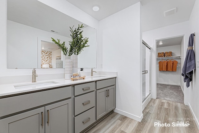 bathroom featuring vanity, wood-type flooring, and a shower with door