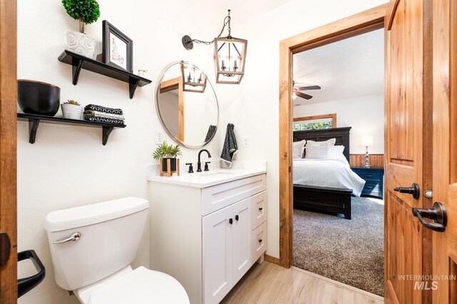 ensuite bathroom featuring ceiling fan, toilet, wood finished floors, and vanity