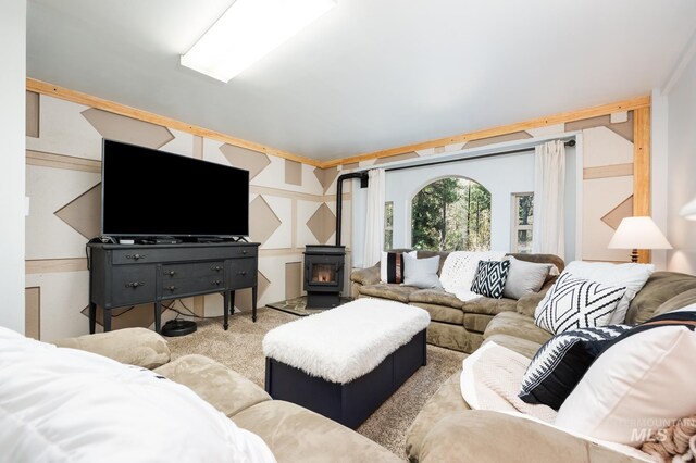 carpeted living area featuring a wood stove