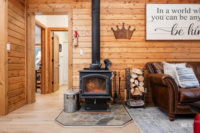 living area featuring a wood stove, wood finished floors, and wood walls