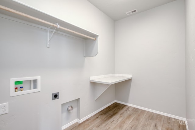 laundry room featuring laundry area, hookup for an electric dryer, hookup for a washing machine, light wood-type flooring, and visible vents