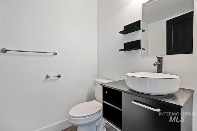 bathroom featuring toilet, vanity, and hardwood / wood-style flooring