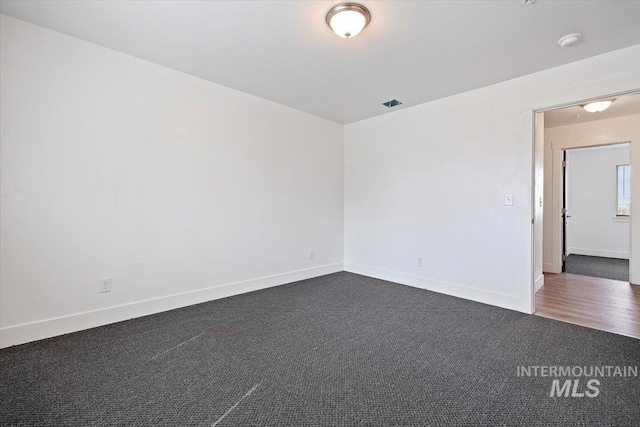 empty room featuring dark colored carpet