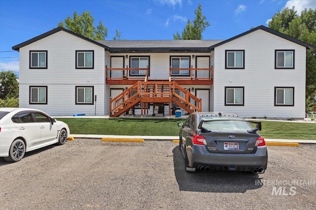 view of front facade with a wooden deck and a front yard