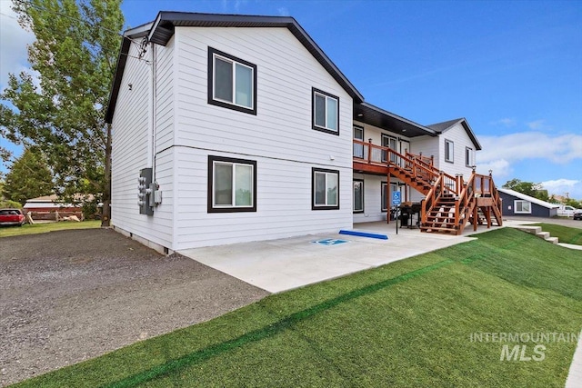 rear view of house with a lawn, a patio, and a deck