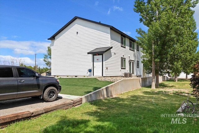 view of side of property featuring central air condition unit and a lawn