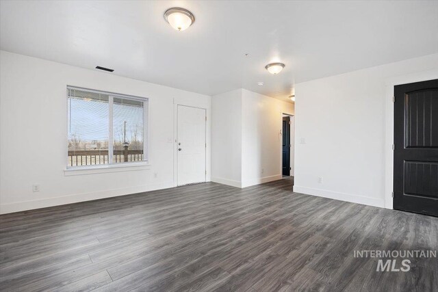 unfurnished room with dark hardwood / wood-style flooring