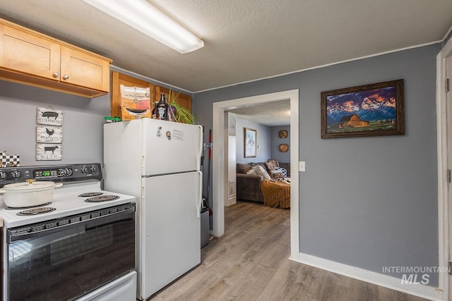 kitchen with range with electric cooktop, light countertops, freestanding refrigerator, light wood-style floors, and a textured ceiling