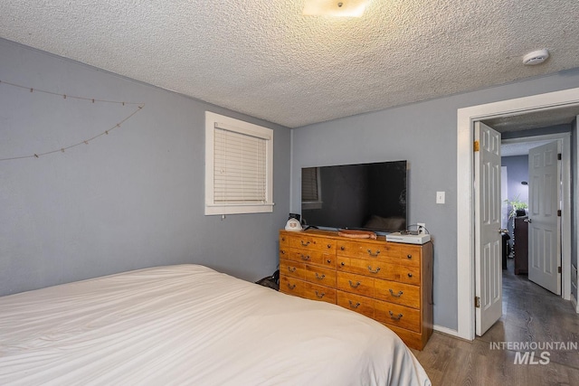 bedroom with a textured ceiling and wood finished floors