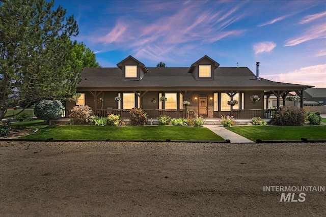 view of front of house featuring covered porch and a lawn