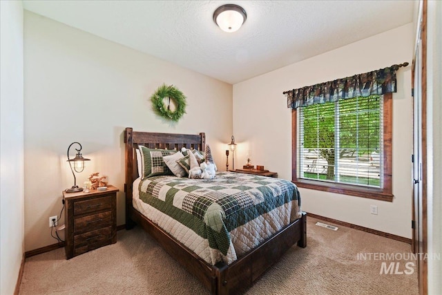 bedroom with a textured ceiling and carpet