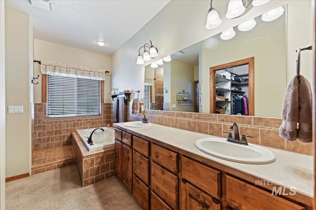 bathroom with tiled tub and vanity