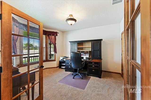 carpeted office with french doors and a textured ceiling