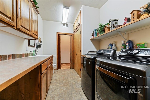 washroom featuring sink, cabinets, and washer and dryer