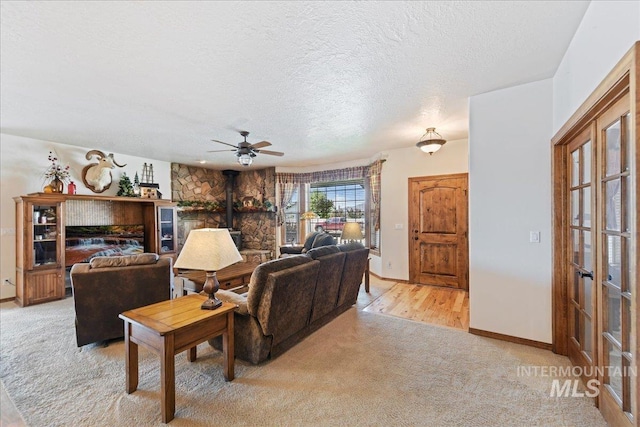 living room with ceiling fan, light colored carpet, and a textured ceiling