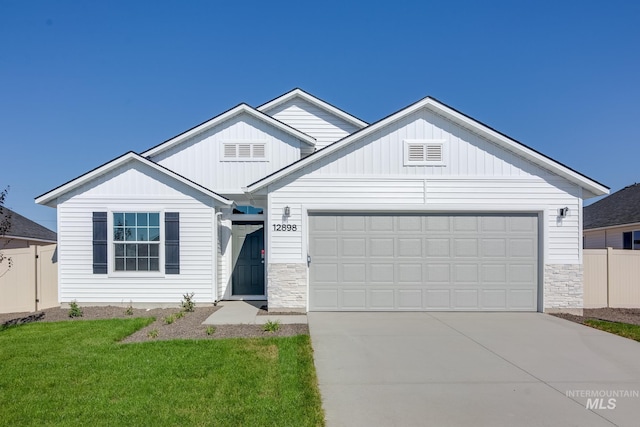 208 Idalou Way, Caldwell, ID 83605 - view of front of property featuring board and batten siding, fence, a garage, concrete driveway, and stone siding