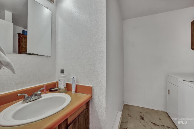 bathroom featuring washing machine and dryer and vanity