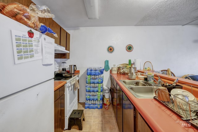 kitchen with white appliances, a textured ceiling, and sink