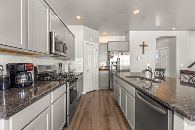 1417 Scranton Ave, Caldwell, ID 83605 - kitchen with stainless steel appliances, gray cabinetry, dark wood finished floors, a sink, and decorative backsplash