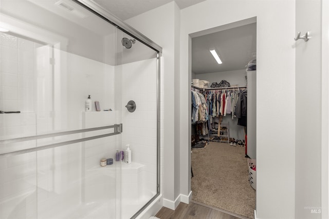 1417 Scranton Ave, Caldwell, ID 83605 - full bathroom featuring a shower stall, a spacious closet, and wood finished floors