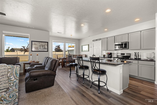 1417 Scranton Ave, Caldwell, ID 83605 - kitchen with stainless steel appliances, a breakfast bar, open floor plan, dark wood-type flooring, and recessed lighting