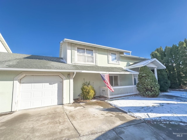 view of property with a porch and a garage