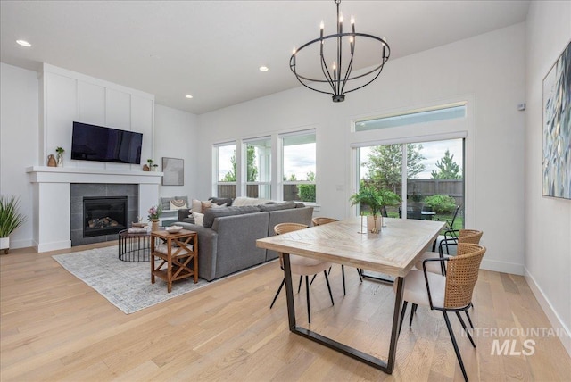 4923 W Canaston St, Meridian, ID 83646 - dining space featuring light wood-style flooring, a tiled fireplace, a chandelier, recessed lighting, and baseboards