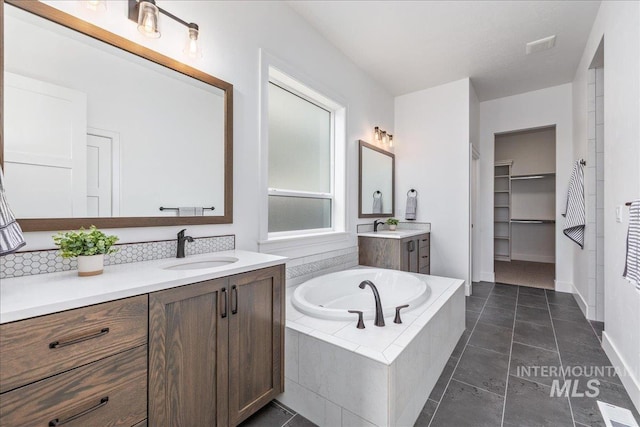 4923 W Canaston St, Meridian, ID 83646 - full bathroom featuring a garden tub, two vanities, a walk in closet, and baseboards