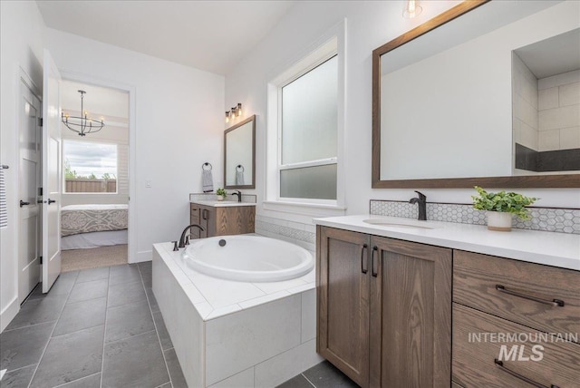 4923 W Canaston St, Meridian, ID 83646 - ensuite bathroom with a garden tub, a chandelier, two vanities, and tile patterned floors
