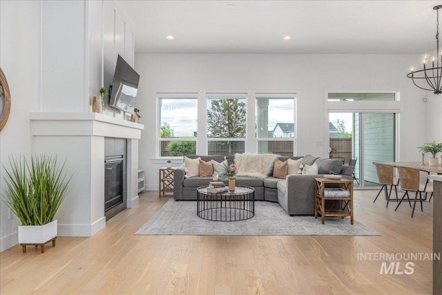 4923 W Canaston St, Meridian, ID 83646 - living area featuring plenty of natural light, a chandelier, light wood finished floors, and a tiled fireplace